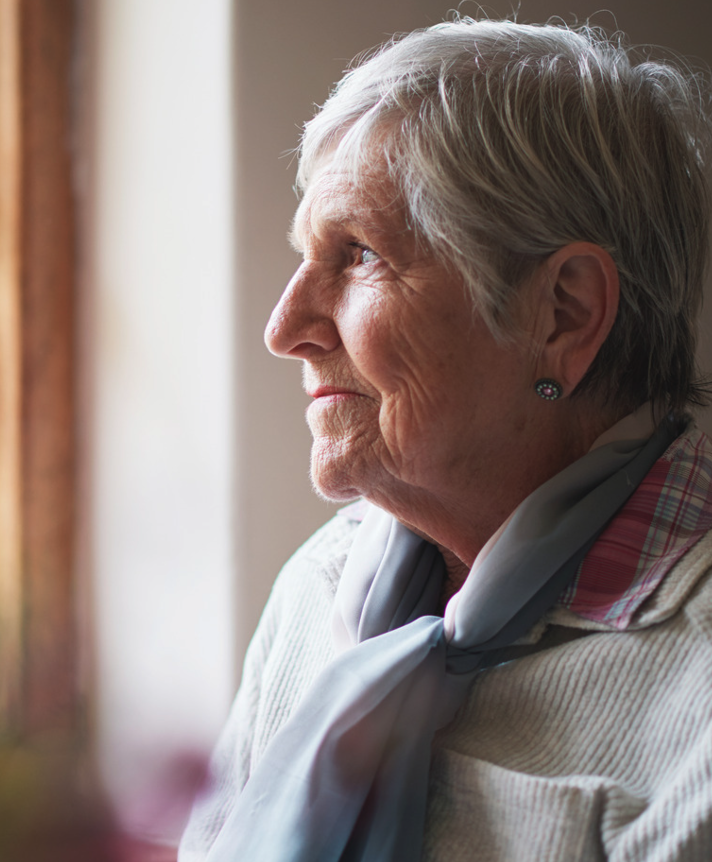 Older woman wearing grey jumper