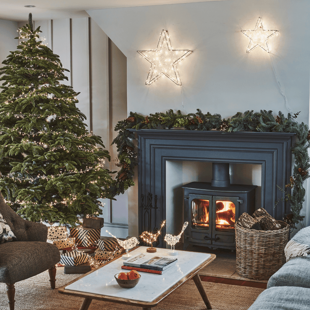 Traditional christmas tree with lights and fireplace with stove