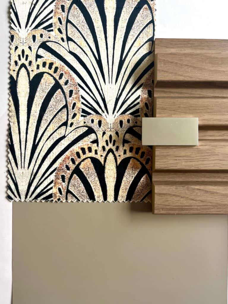 Sample board showing art decor style fabric in orange, browns and black, taupe paint, alnut wood and gold metal