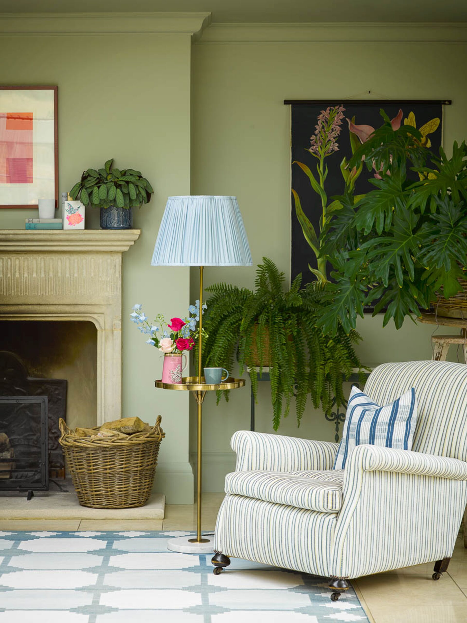 Pooky light Green living room with floor lamp, striped armchair, floral tapestry, and fireplace